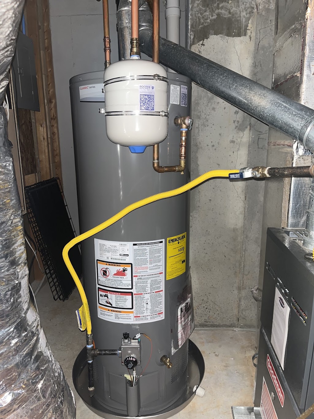 Residential gas water heater installation with copper piping and thermal expansion tank